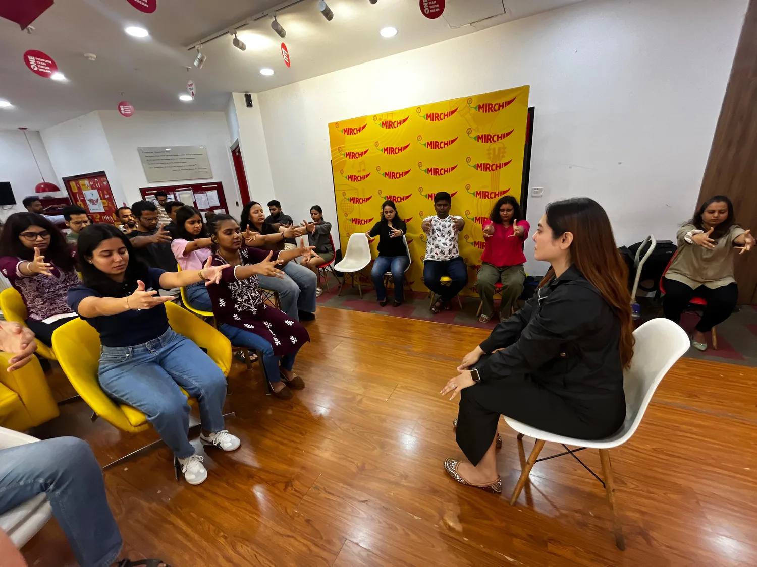Vibha Jain speaking with a group of seated participants during an awareness session about relaxation and focused attention